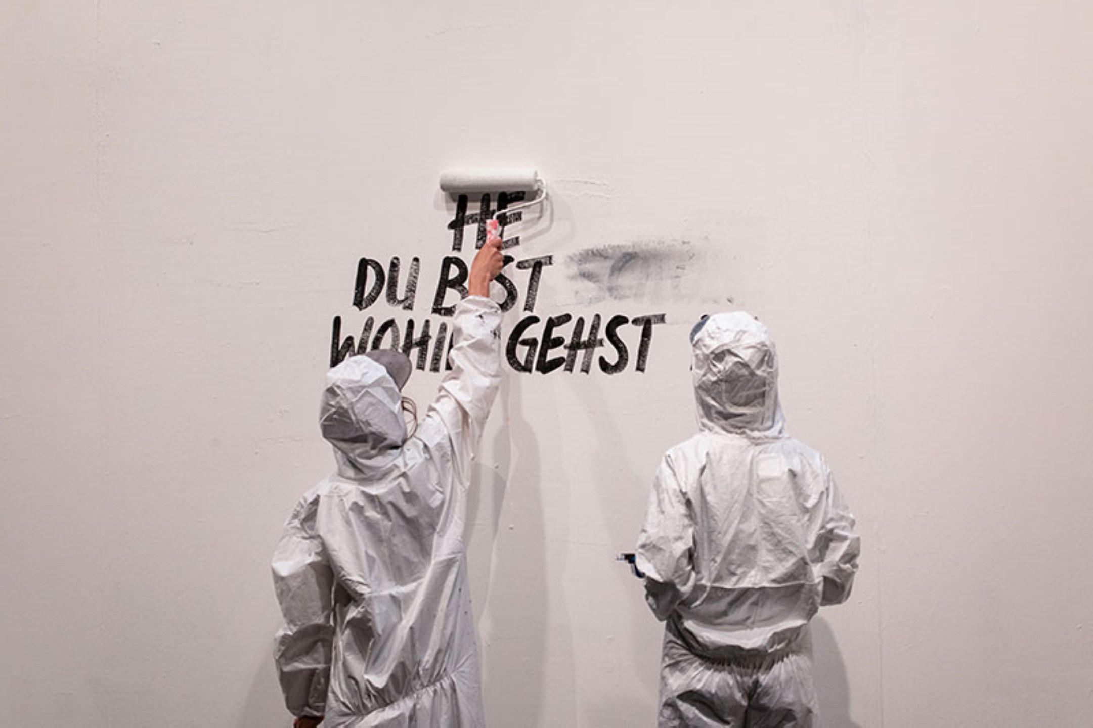 © Claudia Schildnkecht – Isabelle Mauchle et Nina Langensand écrivent et effacent différents mots sur le mur, dans une métaphore de la pluralité des paroles et des vérités.